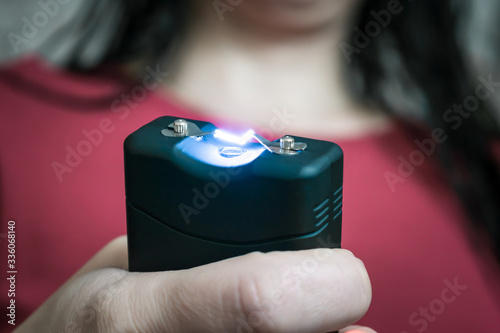 The stun gun in the hands is a close-up. Selective focus