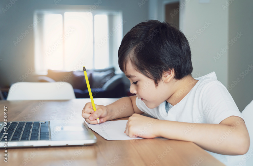 Kid self isolation using computor for his homework,Child using laptop searching information on internet while school off during covid-19 lock down,Social Distancing, learning online education Kid self isolation using computor for his homework,Child using laptop searching information on internet while school off during covid-19 lock down,Social Distancing, learning online education