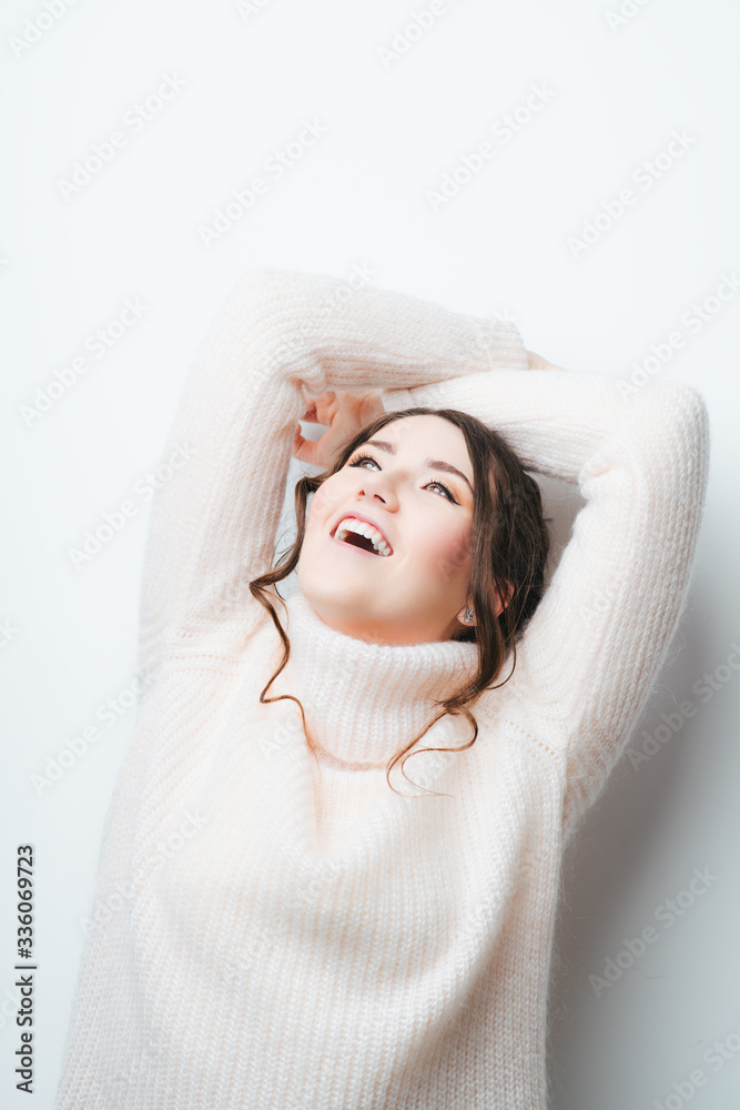 Beautiful student sitting on a chair, isolated over a gray background