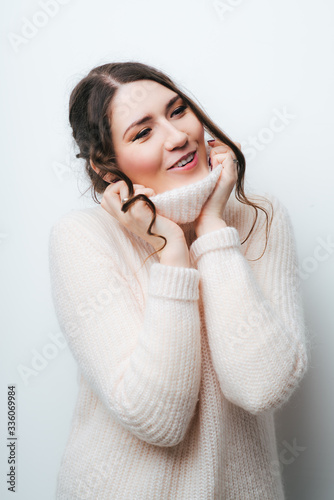Gorgeous young brunette woman in warm knitted sweater.