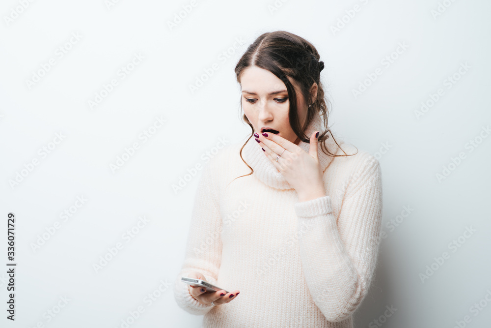 on a white background frightened girl looks at the phone on a white background frightened girl looks at the phone
