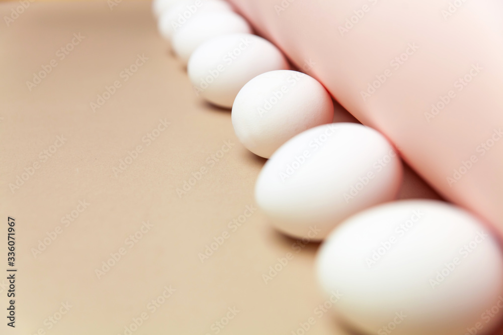 Creative Easter beige and pink background with white eggs.