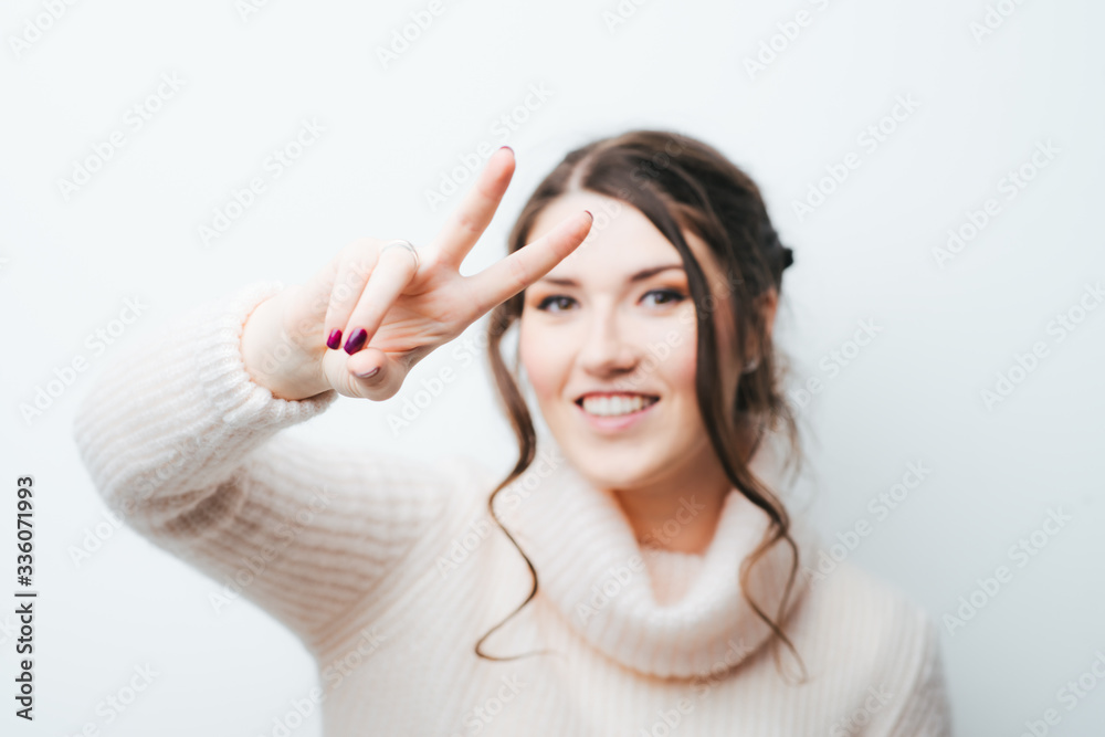 on a white background girl showing two fingers on a white background girl showing two fingers