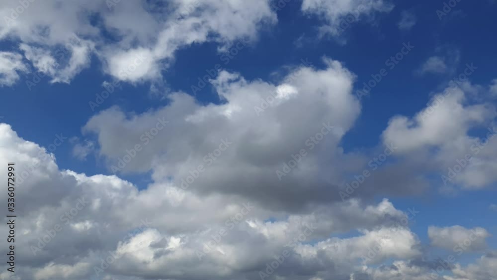 Blue summer sky with dense thick rain clouds moving across the heavens. Fast cloud formation and movement creating a surreal time lapse. Blue summer sky with dense thick rain clouds moving across the heavens. Fast cloud formation and movement creating a surreal time lapse.