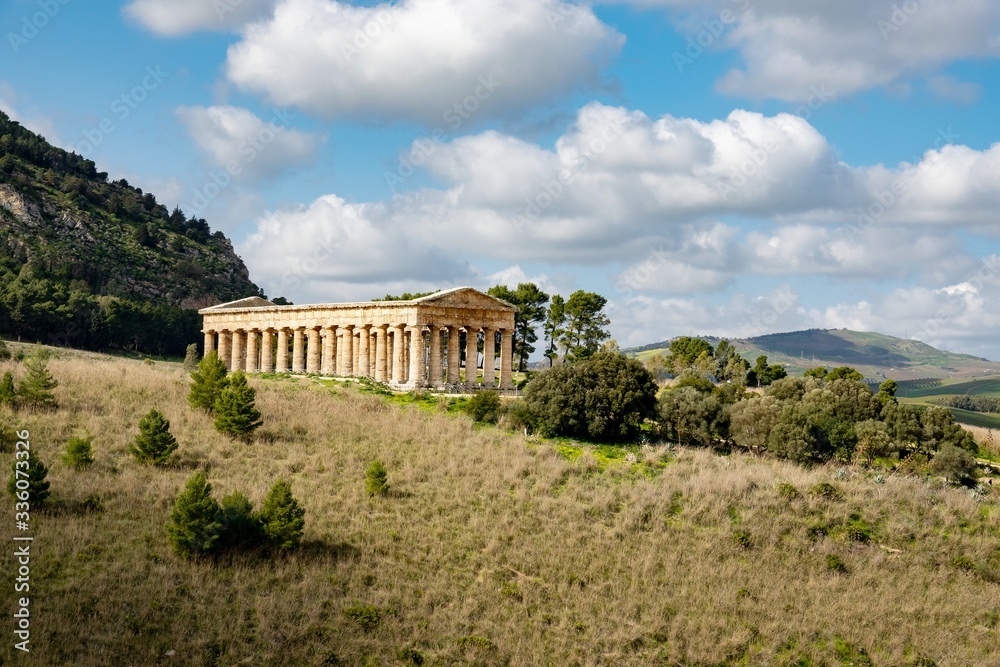 Landscape with ancient Doric temple of Segesta, Sicily in nice sunny spring day with cloud shadows