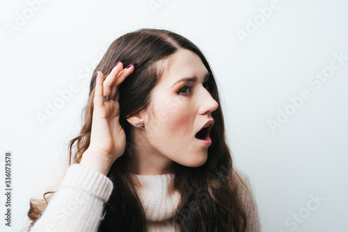 brunette girl is listening on a white background