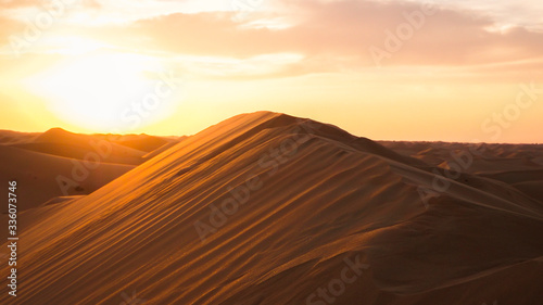 Amazing desert sunset. Beautiful Arabian desert with warm colors. Colorful contours of sand dunes at Abu Dhabi. © deliris