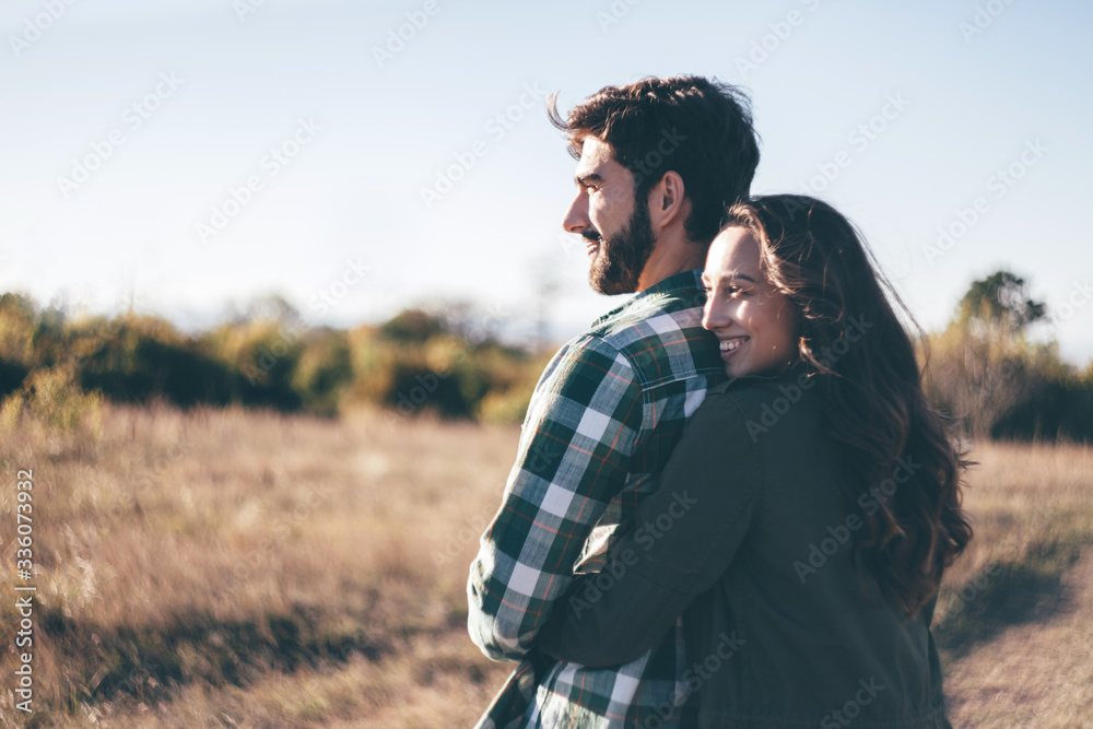 Young beautiful couple walking outside on beautiful sunset. Perfect romantic landscape for lovestory. Two hipsters-lovers hugging. Young beautiful couple walking outside on beautiful sunset. Perfect romantic landscape for lovestory. Two hipsters-lovers hugging.