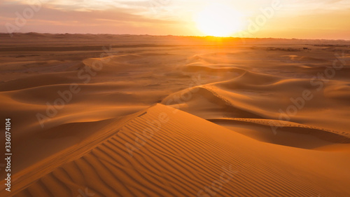 Amazing desert sunset. Beautiful Arabian desert with warm colors. Colorful contours of sand dunes at Abu Dhabi. © deliris