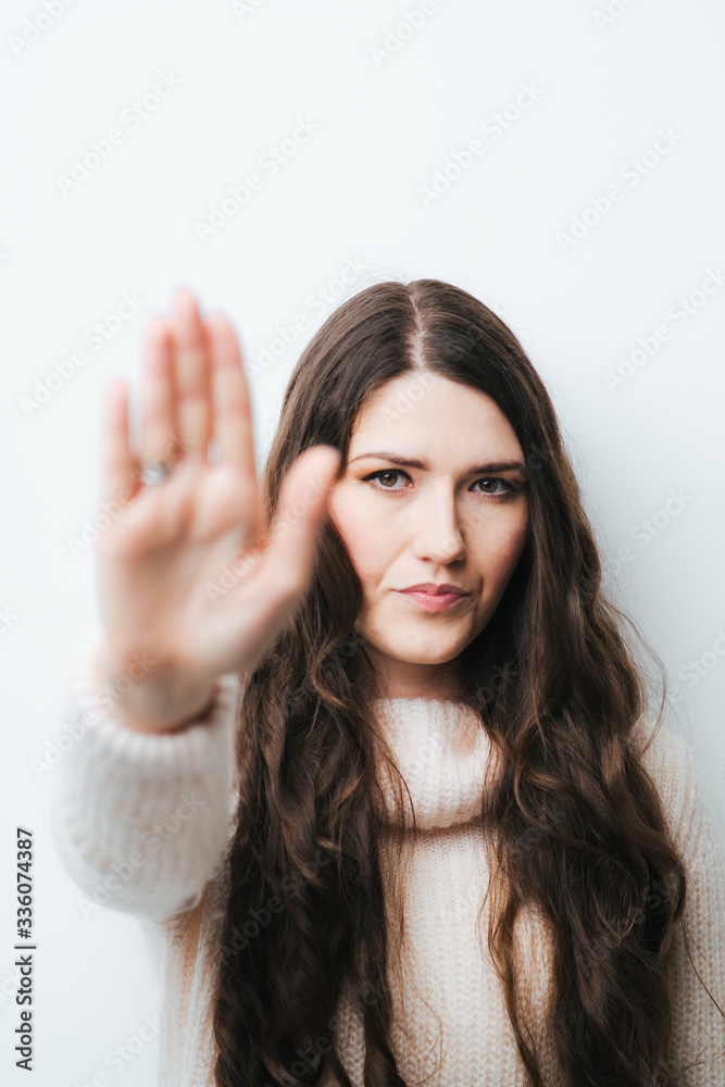 on a white background young girl with long hair shows stop on a white background young girl with long hair shows stop