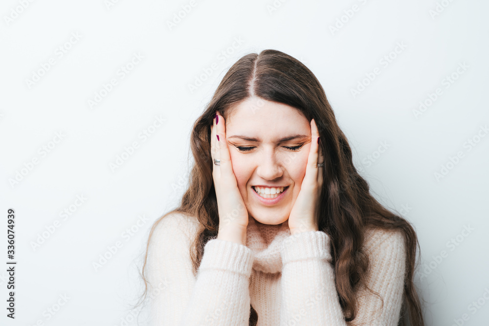 beautiful long-haired girl had a headache and holding his head with hands on a white background beautiful long-haired girl had a headache and holding his head with hands on a white background
