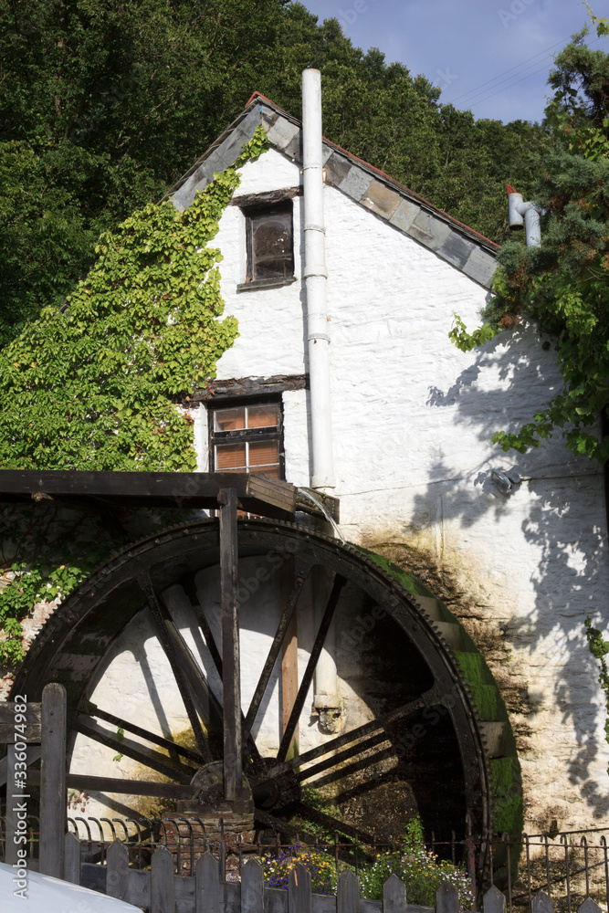 Polperro (England), UK - August 16, 2015: Tipycal house with a mill in Polperro village, Cornwall, England, United Kingdom. Polperro (England), UK - August 16, 2015: Tipycal house with a mill in Polperro village, Cornwall, England, United Kingdom.