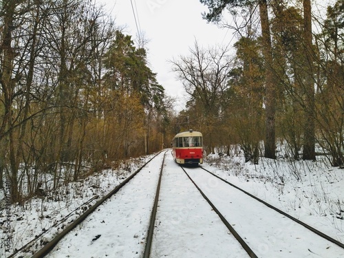 Tram going on rails in snowy winter forest
