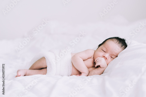 Smiling baby boy lying on a white bed, Family morning at home,Children hygiene.
