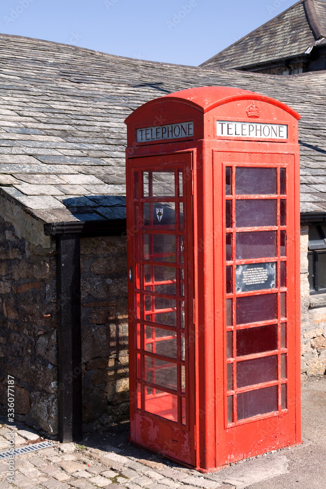 Bibury (England), UK - August 05, 2015: A red phone box in Bibury village, Gloucestershire, England, United Kingdom. Bibury (England), UK - August 05, 2015: A red phone box in Bibury village, Gloucestershire, England, United Kingdom.