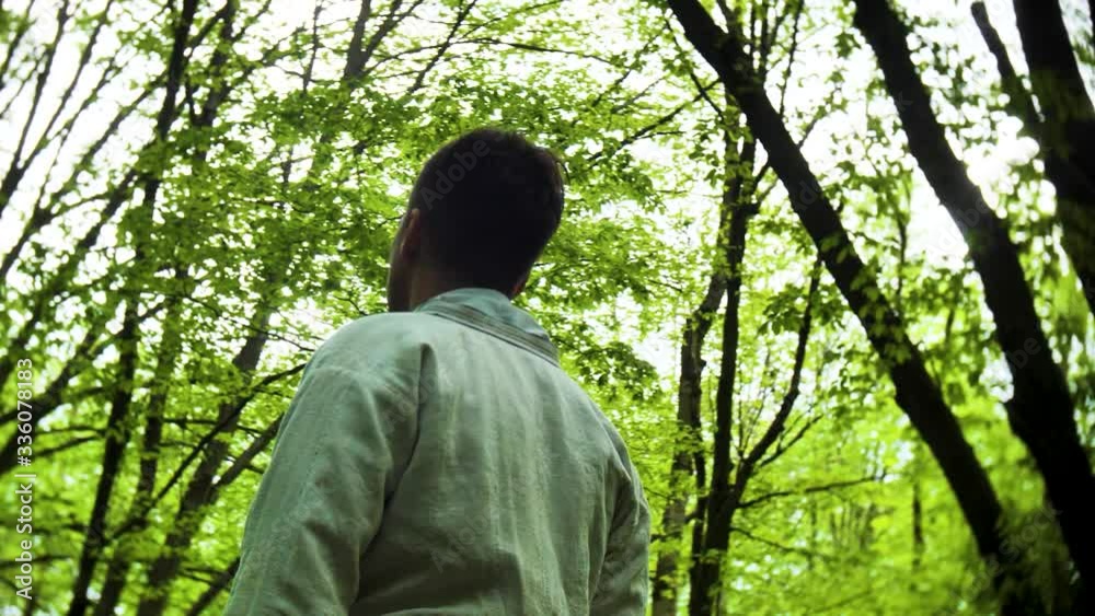 Young man in slavic costume stands in forest Young man in slavic costume stands in forest