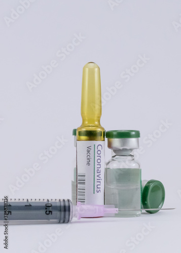 Portrait mode shot of Coronavirus Vaccine ampoule with syringe and vials.