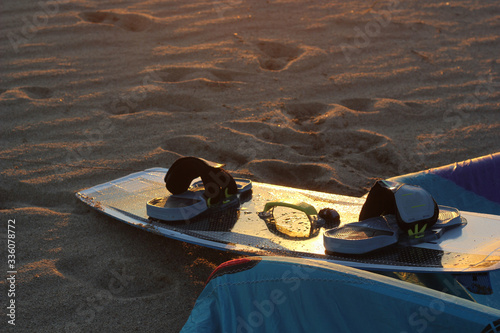 wet blue and white kiteboard on the sand in the sunset