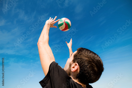 young man playing beach volleyball