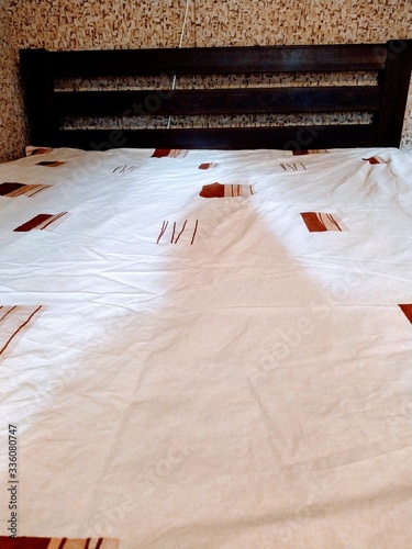 Fotografie Made-up wooden bed in bedroom