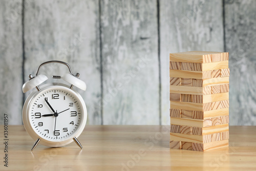 Wallpaper Mural White retro alarm clock on a table with small wooden bricks. Tower play. Wooden background Torontodigital.ca