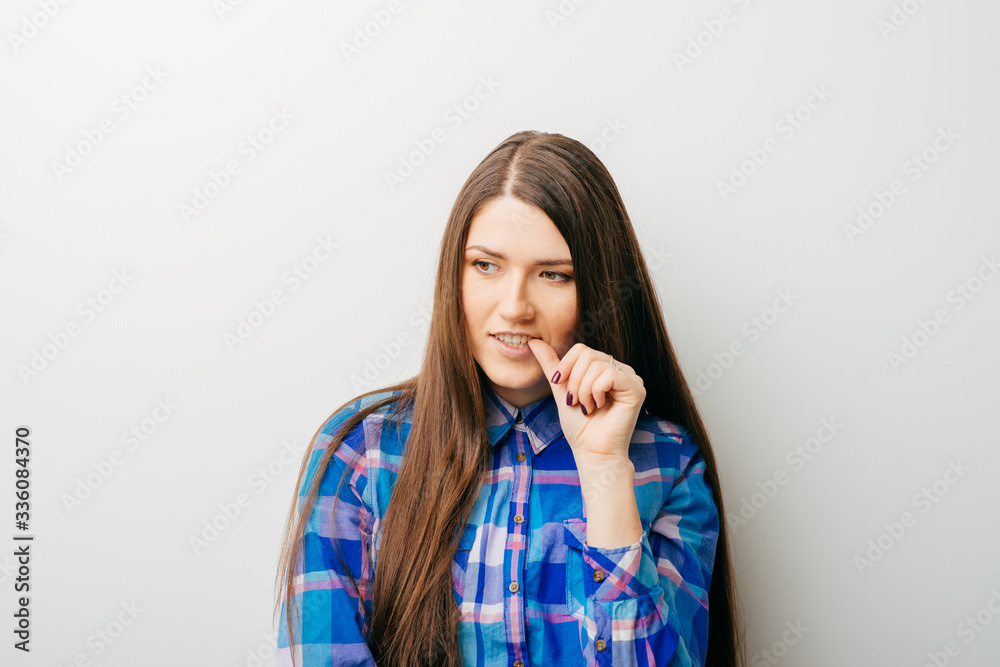 on a white background young girl bites his nails on a white background young girl bites his nails