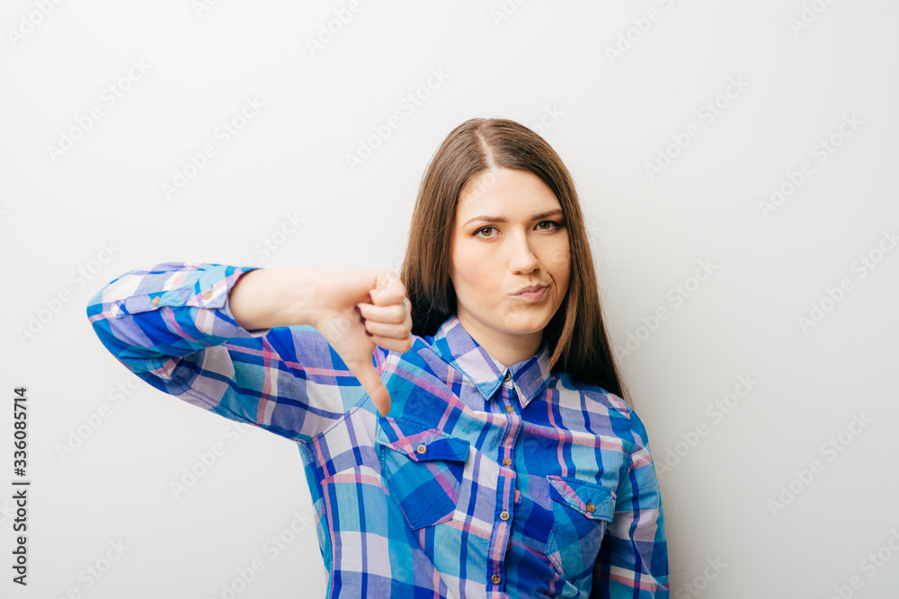 long-haired beautiful girl showing thumbs down, isolated over white background long-haired beautiful girl showing thumbs down, isolated over white background
