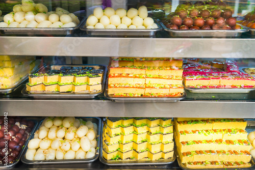 Canvas Print Many delicious traditional indian sweets and desserts at storefront at asian foo