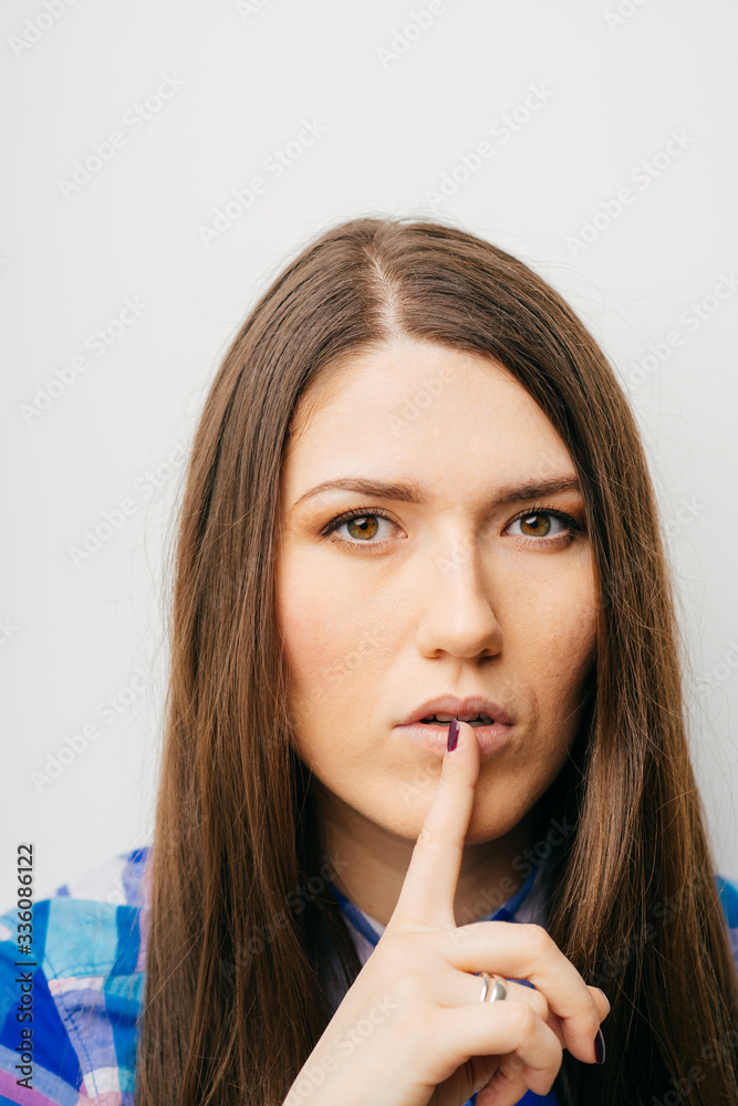 long-haired beautiful girl showing quietly finger, isolated on white background long-haired beautiful girl showing quietly finger, isolated on white background