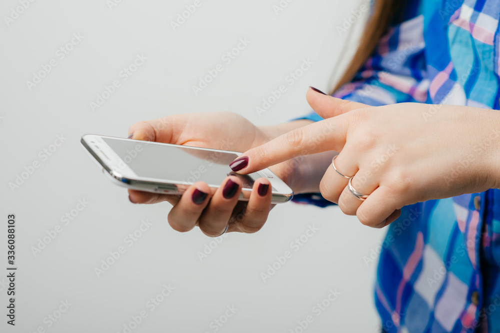 young woman typing on mobile phone on white background