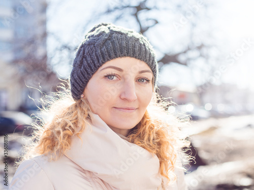 Smiling girl in a white clohtes looking at camera. Young woman winter portrait photo