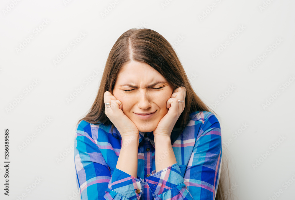 Young woman covering her ears Young woman covering her ears