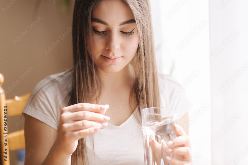 Portrait of woman eating pills. Female at home on quarantine. Self isolation. Helthy woman take vitamines Portrait of woman eating pills. Female at home on quarantine. Self isolation. Helthy woman take vitamines
