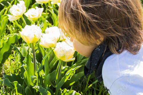A boy smelling flowers in the field
