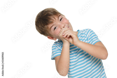 Little funny boy in a blue striped t-shirt put his hands to his face while portraying a spyglass isolated on a white background.