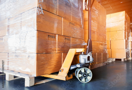Interior of warehouse, close up hand pallet truck with stack package boxes on pallets, warehouse industry delivery shipment goods, logistics, transport