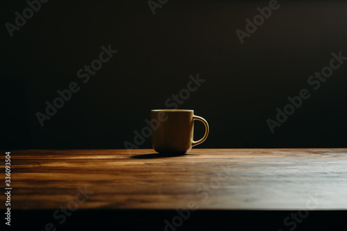 Coffee cup on wooden table in livingroom. Background with free text space.