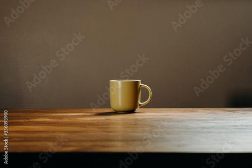 Coffee cup on wooden table in livingroom. Background with free text space.