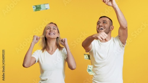 Surprised happy couple enjoying money rain banknotes falling down. Success, business, and fortune concept. Slow motion