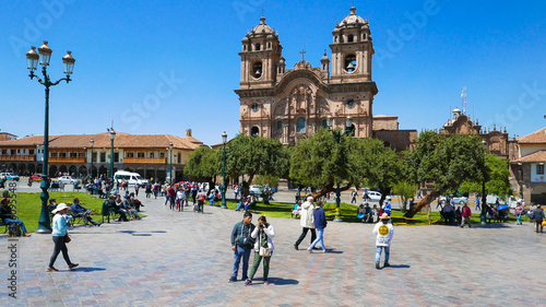 Cusco Peru tourists in square of arms gardens and cathedral