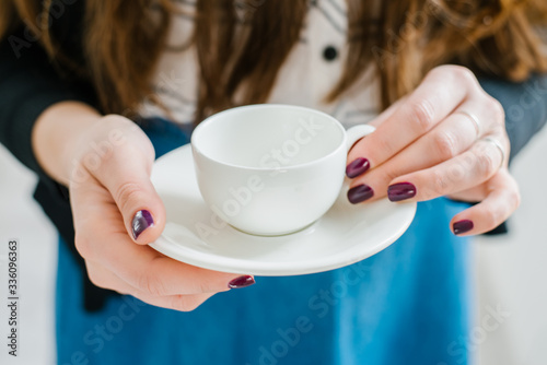 young girl in glasses with white cup and saucer