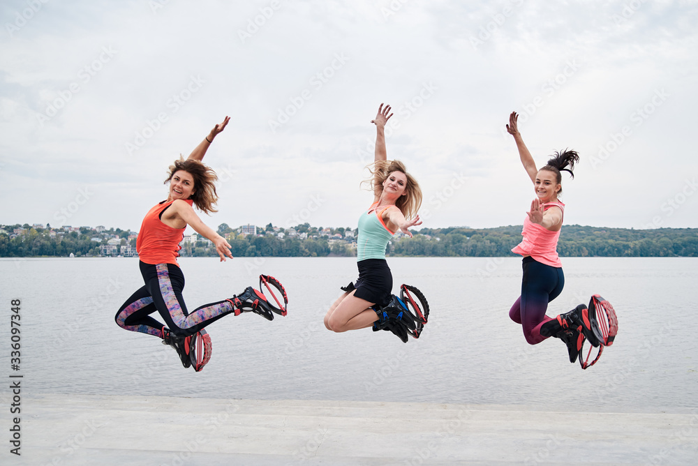 A Group of Young Fit Slim Women in Kangoo Jumps, Training in Front of City  Lake in Summer. Four Girls, Wearing Colorful Sports Stock Photo - Image of  jumps, jumpers: 184326964