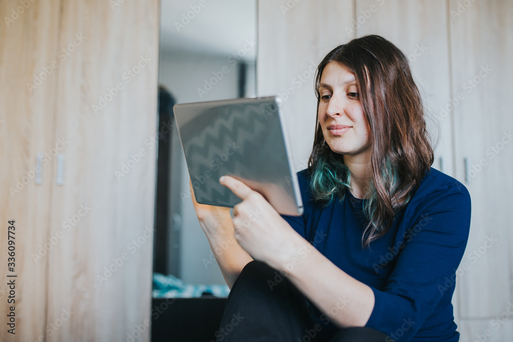 Woman bonding with friends during quarantine indoors. Female using tablet. Woman bonding with friends during quarantine indoors. Female using tablet.