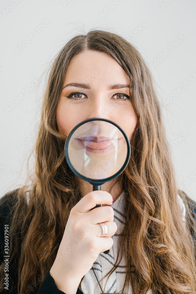 Girl with a magnifying glass in front of her mouth Girl with a magnifying glass in front of her mouth