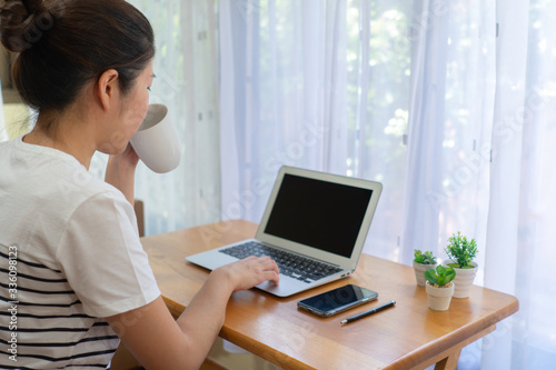 A woman taking a break after working at the desk in the living room. work from home, social distancing, isolation, covid-19, coronavirus, freelance, business, technology concept