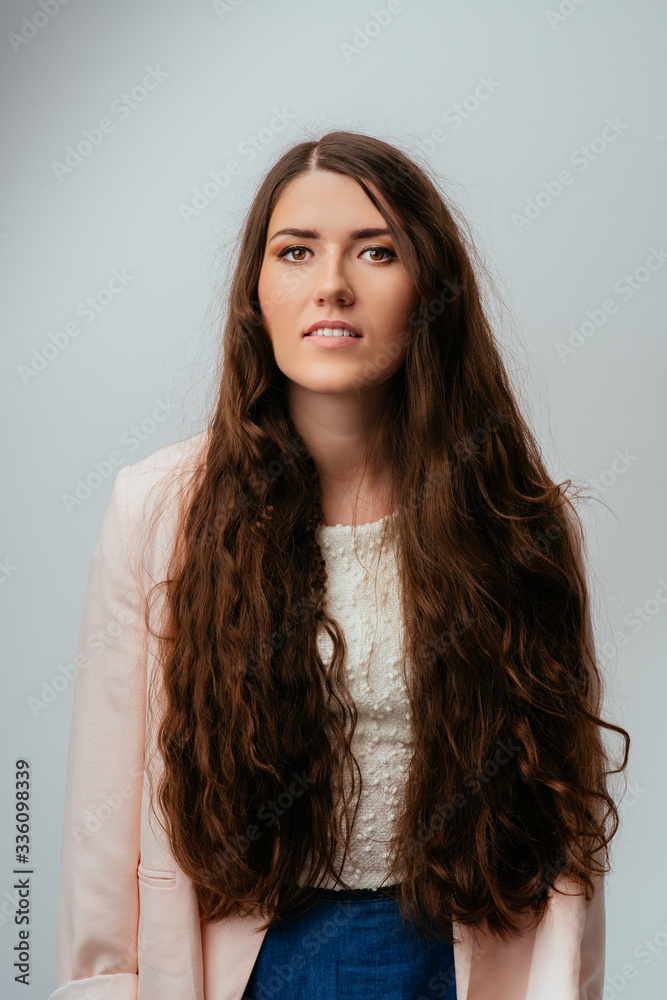 Casual woman with long curly brunette hair smiling - isolated over white Casual woman with long curly brunette hair smiling - isolated over white