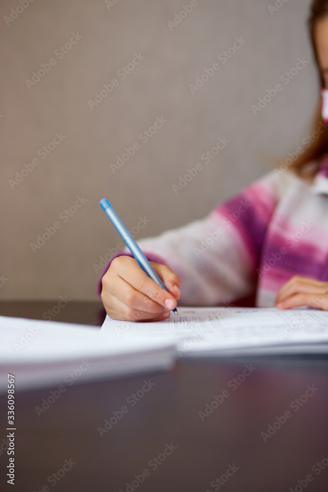 Unrecognizable girl doing homework, writing education concept, Coronavirus Unrecognizable girl doing homework, writing education concept, Coronavirus