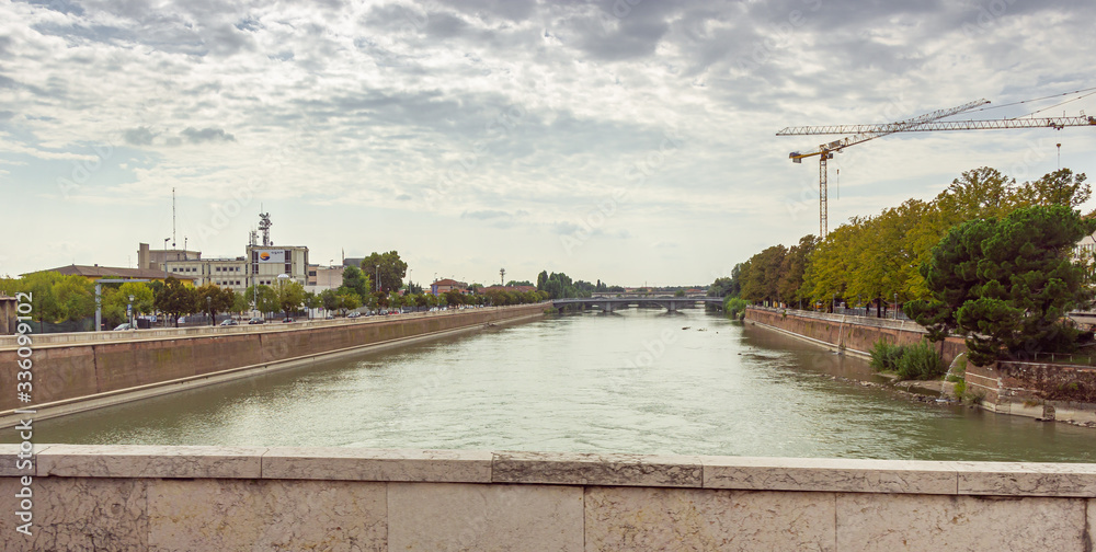 View from the bridge to the Adige rive and embankments from two sides in Verona city, Italy.