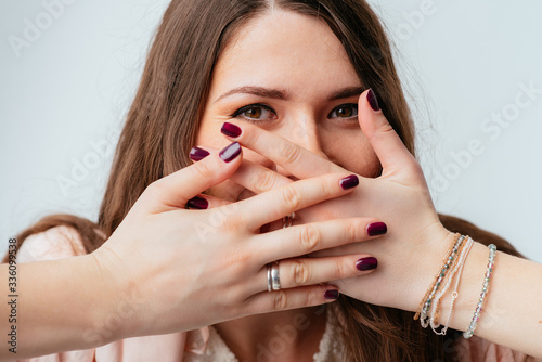 girl covers her mouth with her hands