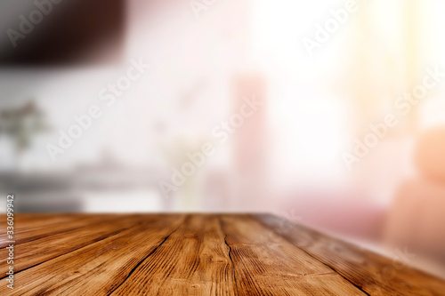 Wooden table in the living room by a sunny window on a warm day